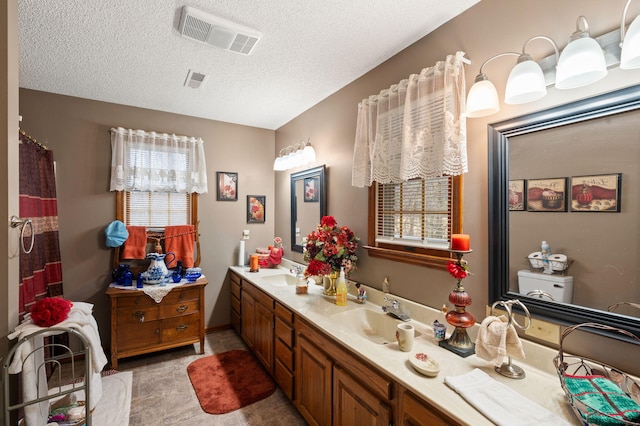 bathroom featuring plenty of natural light, visible vents, and a sink