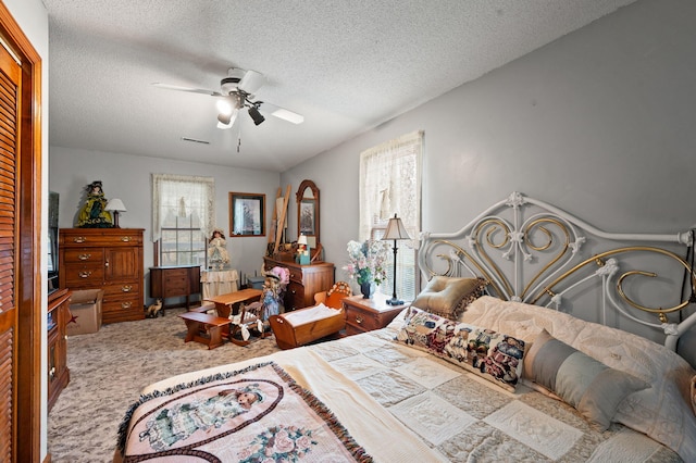 carpeted bedroom with a ceiling fan, a textured ceiling, and visible vents