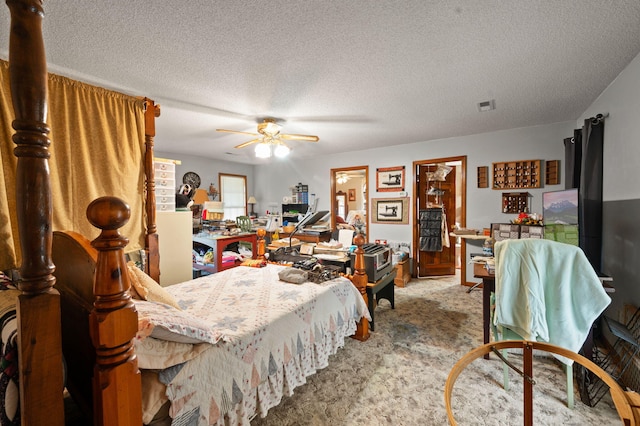 carpeted bedroom featuring ceiling fan, a textured ceiling, and visible vents