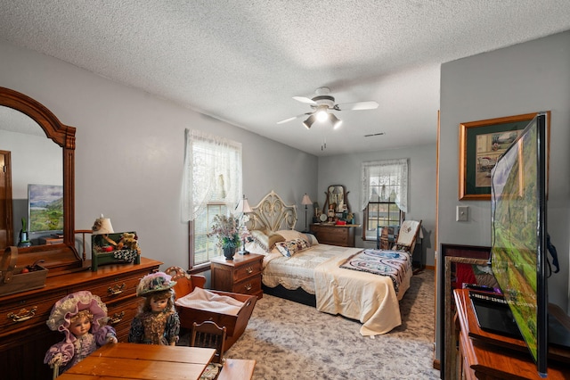 carpeted bedroom with a ceiling fan, a textured ceiling, and multiple windows
