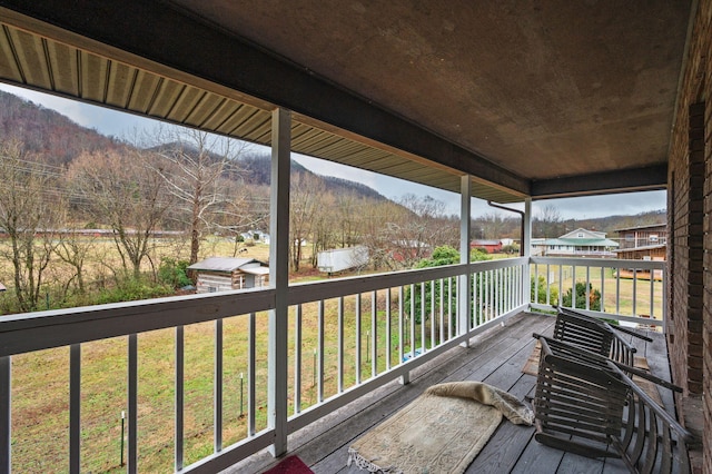 deck featuring a lawn and a mountain view