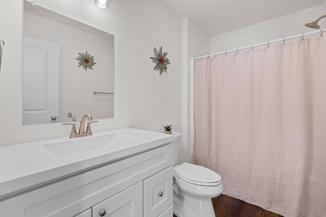 bathroom with toilet, wood finished floors, vanity, and a shower with curtain