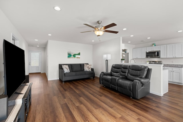 living area featuring baseboards, a ceiling fan, dark wood-style flooring, and recessed lighting