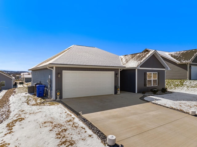 ranch-style home with a garage, driveway, and a shingled roof