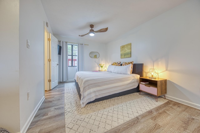 bedroom with wood finished floors, baseboards, and ceiling fan