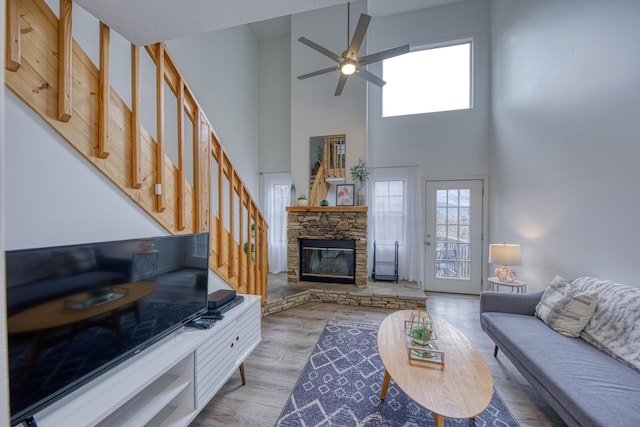 living room featuring a wealth of natural light, a ceiling fan, wood finished floors, and a fireplace