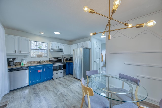 kitchen featuring blue cabinetry, appliances with stainless steel finishes, white cabinets, and under cabinet range hood