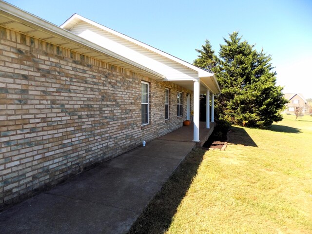 view of side of home with a lawn