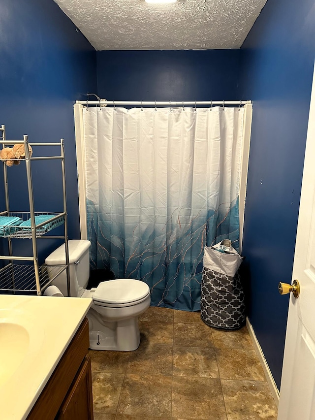 bathroom with vanity, a textured ceiling, and toilet