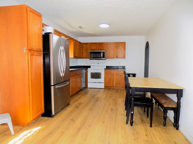 kitchen with stainless steel appliances and light hardwood / wood-style floors