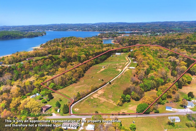 birds eye view of property with a water view and a view of trees