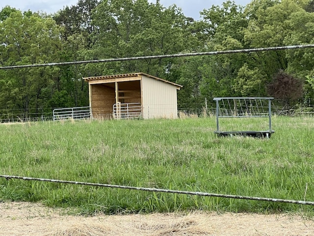 view of outbuilding with an exterior structure, an outdoor structure, and a wooded view