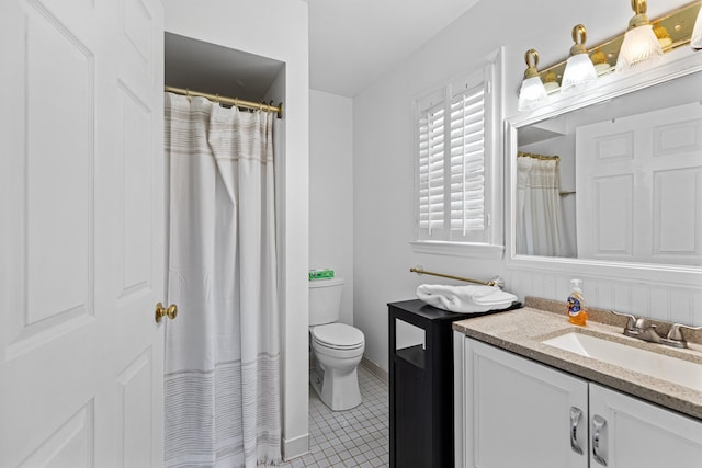 bathroom with a shower with curtain, vanity, toilet, and tile patterned floors