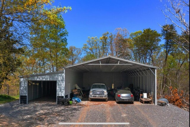 view of parking / parking lot featuring a detached garage and a carport