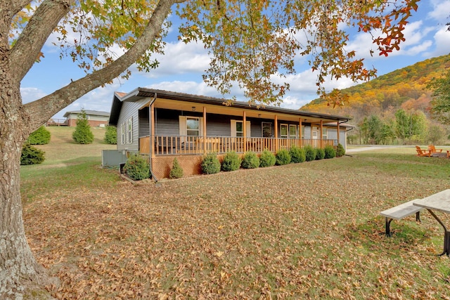 view of front of property featuring a mountain view and a front lawn