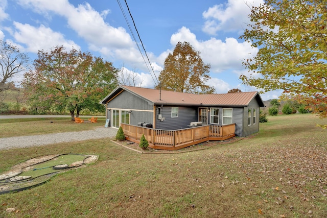 rear view of house with a yard and a deck