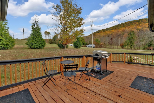 wooden terrace with a grill and a yard