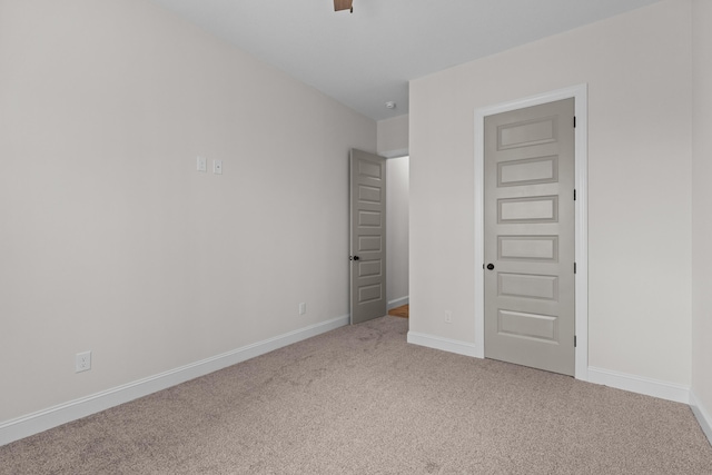 unfurnished bedroom with baseboards and carpet