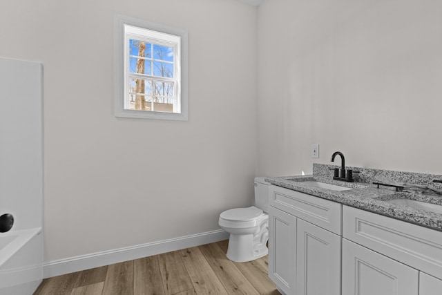 full bath with toilet, a sink, baseboards, and wood finished floors