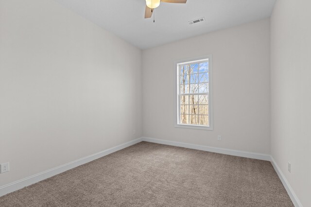empty room featuring carpet floors, baseboards, visible vents, and ceiling fan