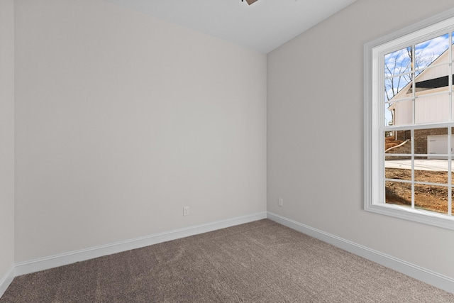 carpeted spare room with baseboards and ceiling fan