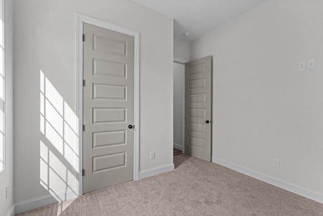 unfurnished bedroom with carpet floors and baseboards