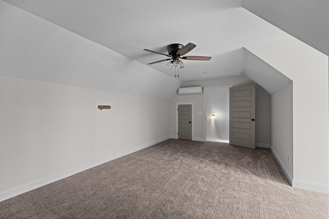 bonus room featuring a wall mounted AC, carpet flooring, lofted ceiling, baseboards, and ceiling fan