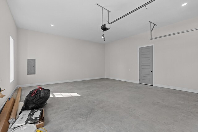 garage featuring baseboards, electric panel, recessed lighting, and a garage door opener
