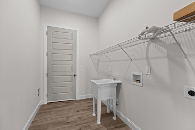 clothes washing area with wood finished floors, electric dryer hookup, laundry area, baseboards, and hookup for a washing machine