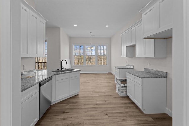 kitchen with dishwasher, white cabinetry, a sink, stone counters, and light wood-type flooring