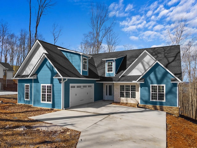 view of front of home with driveway, a shingled roof, and a garage