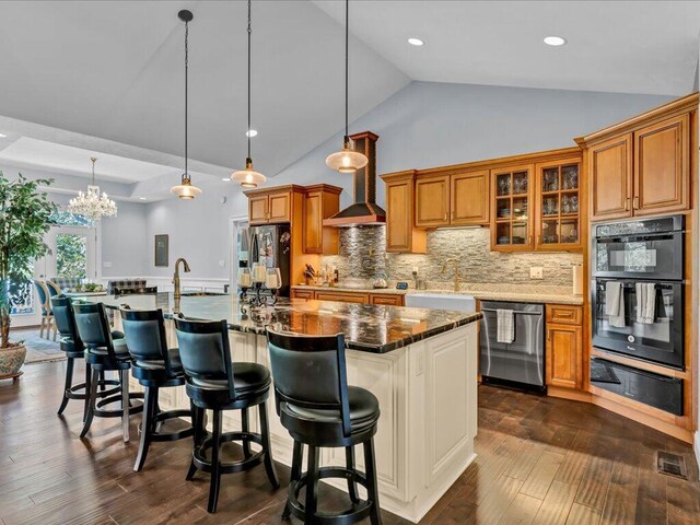 kitchen featuring pendant lighting, dark stone countertops, backsplash, and appliances with stainless steel finishes