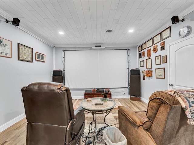 home theater room with crown molding and light hardwood / wood-style floors