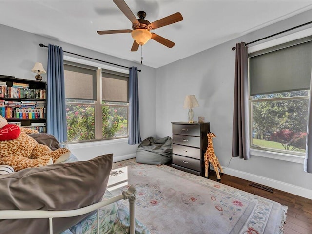 living area featuring ceiling fan and dark wood-type flooring