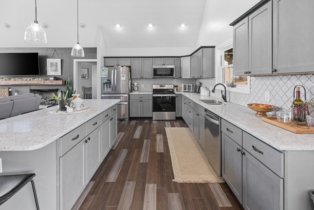 kitchen featuring gray cabinetry, sink, hanging light fixtures, stainless steel appliances, and dark hardwood / wood-style flooring