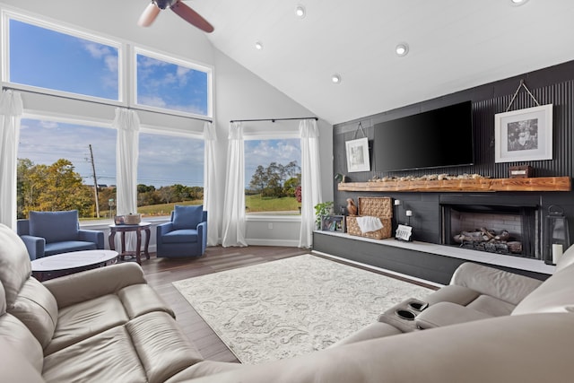 living room with wood-type flooring, vaulted ceiling, and ceiling fan