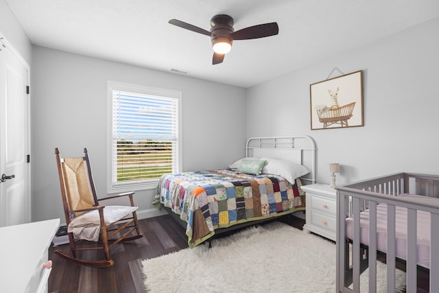 bedroom featuring ceiling fan, dark hardwood / wood-style flooring, and a closet