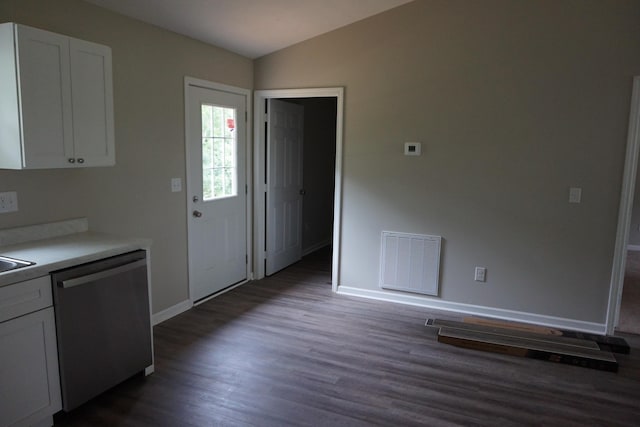 kitchen featuring white cabinets, vaulted ceiling, stainless steel dishwasher, and dark wood-type flooring