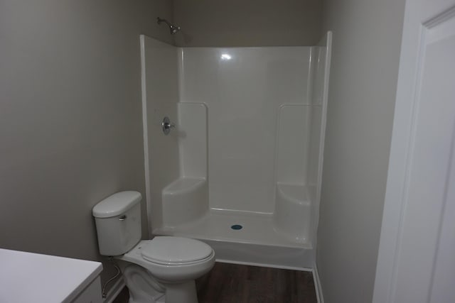 bathroom featuring hardwood / wood-style floors, vanity, toilet, and walk in shower