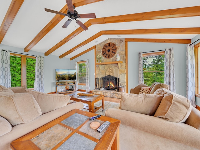 living room featuring plenty of natural light, a stone fireplace, and a ceiling fan