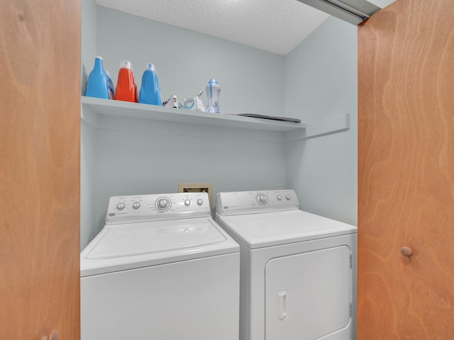 laundry area with washer and clothes dryer and a textured ceiling