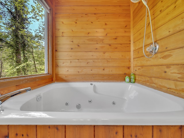 full bath featuring a whirlpool tub and wood walls