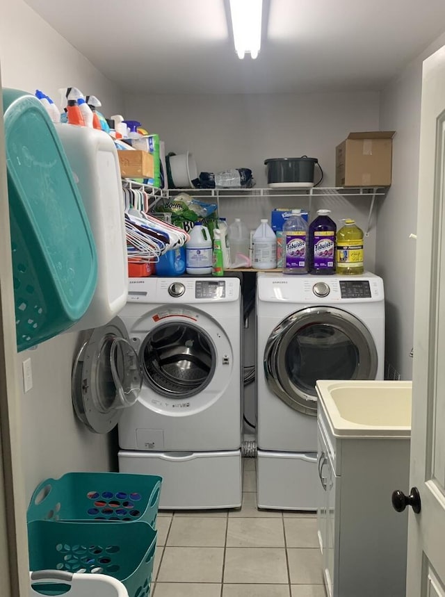 laundry area with light tile patterned flooring, washing machine and dryer, and laundry area