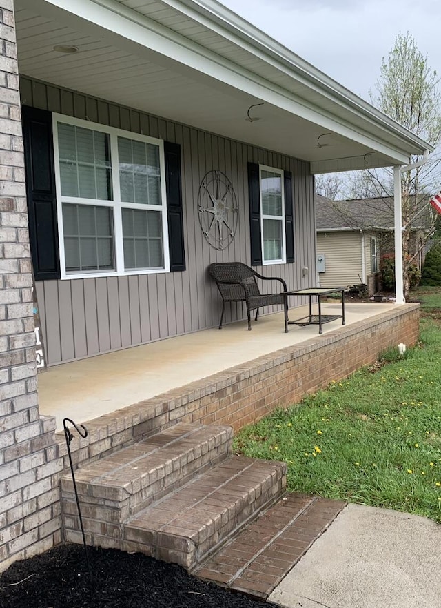 property entrance with covered porch and board and batten siding