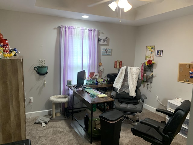 office space with a ceiling fan, a raised ceiling, carpet, and baseboards