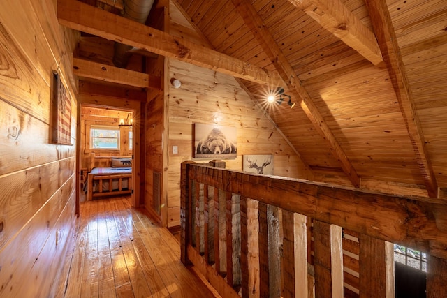 hall with lofted ceiling with beams, wooden walls, hardwood / wood-style floors, and wood ceiling