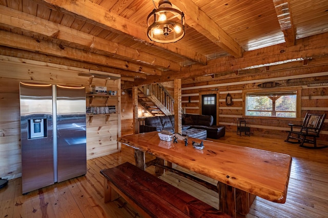 unfurnished dining area featuring beamed ceiling, light hardwood / wood-style floors, wooden ceiling, and wood walls