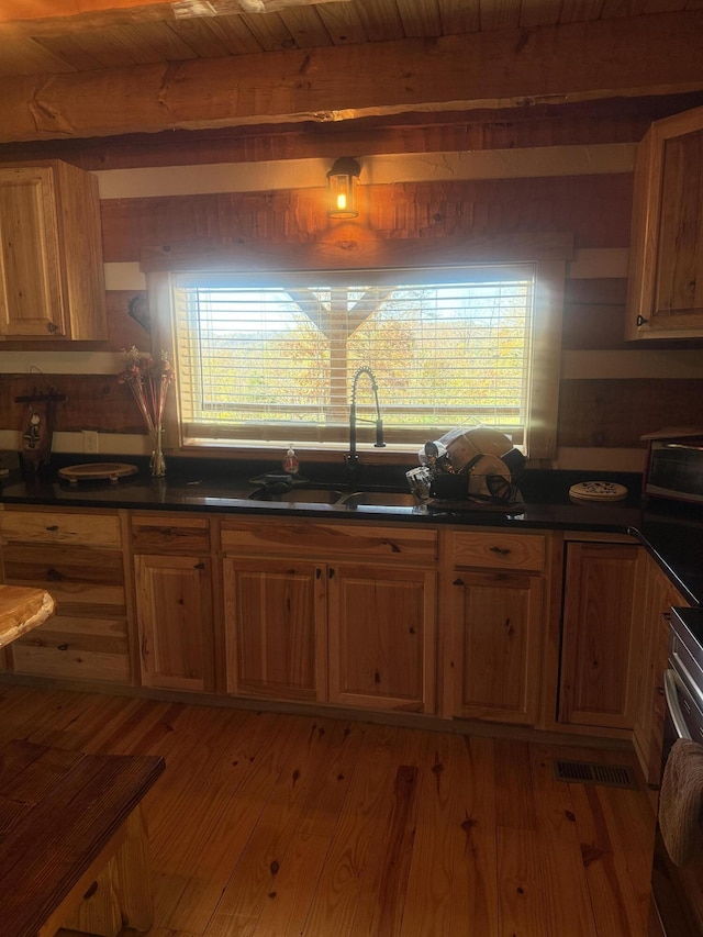 kitchen featuring beam ceiling, sink, wooden ceiling, and hardwood / wood-style flooring