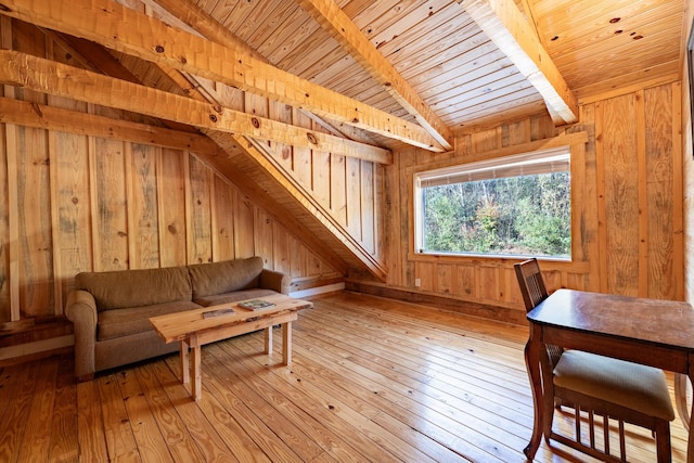 interior space featuring lofted ceiling with beams, light hardwood / wood-style floors, wooden ceiling, and wooden walls