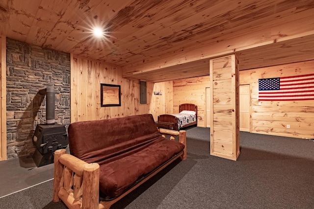 bedroom featuring a wood stove, dark colored carpet, electric panel, wood walls, and wood ceiling